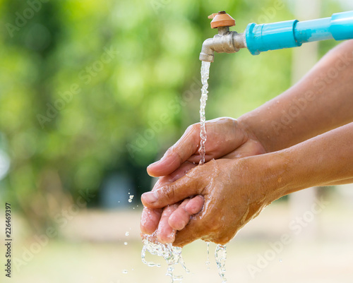 Water pouring in man hand on nature background environment issues.Health care concept.