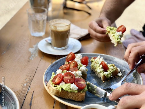 Smashed avocado with feta cheese and cherry tomatoes on toast brunch