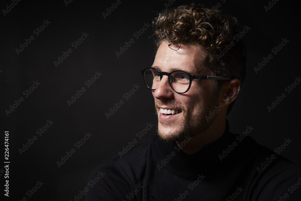 Smiling guy in glasses in studio