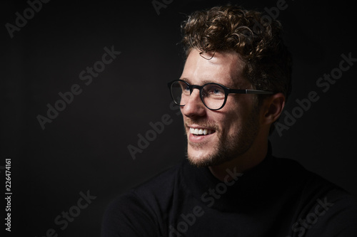 Smiling guy in glasses in studio