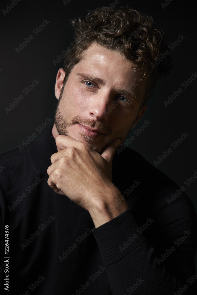 Deep in thought man in dark studio Deep in thought man in dark studio