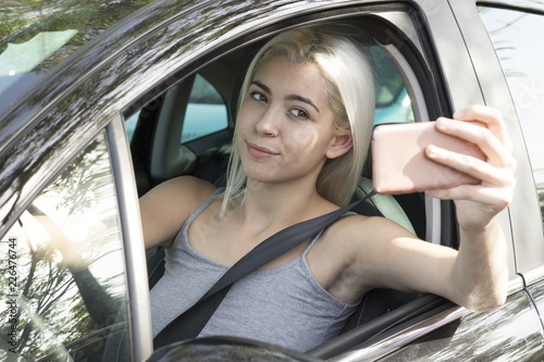 Young girl in the car with a mobile phone photo