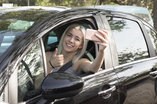 Young girl in the car with a mobile phone photo