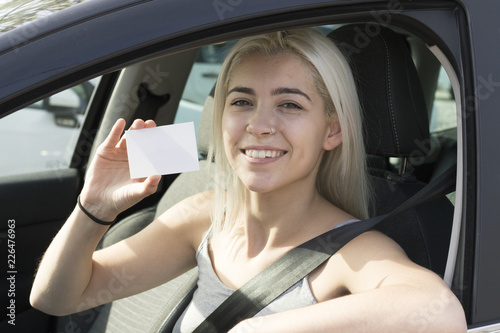 young girl in the car with card in hand photo