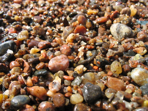 summer wet stones and sand seaside pebble close up