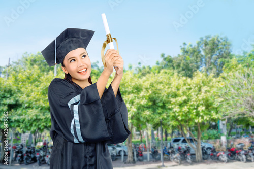 Beautiful asian student girl celebrate her graduation with cap and diploma scroll