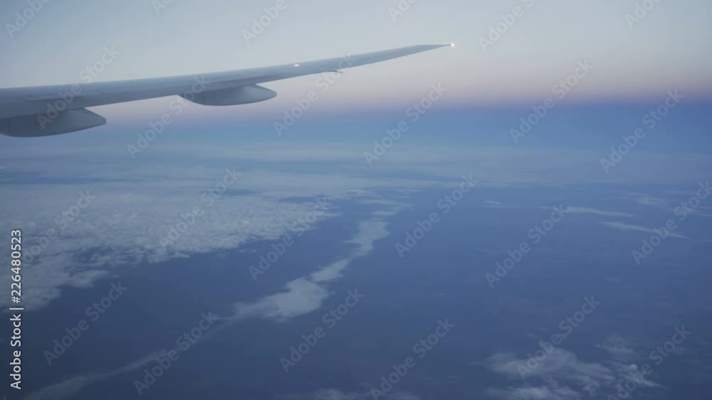 Clouds seen through the window of jet airplane. Airplane flies above the weather Clouds seen through the window of jet airplane. Airplane flies above the weather