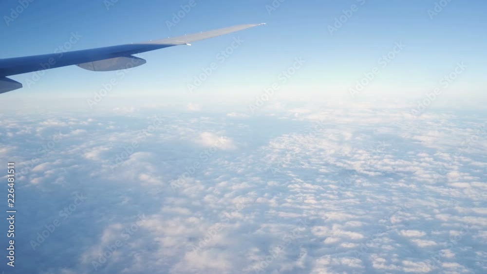 Clouds seen through the window of jet airplane. Airplane flies above the weather Clouds seen through the window of jet airplane. Airplane flies above the weather