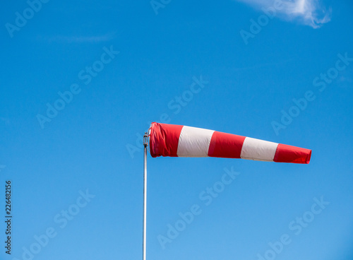 The windsock in wind against blue sky