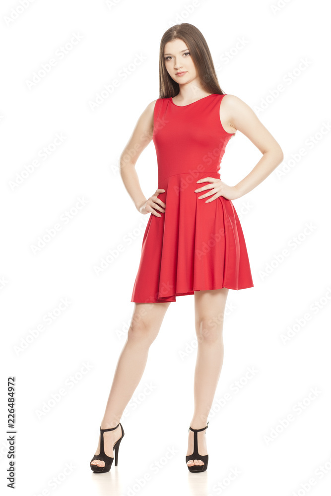 Young woman in short red dress and high heels on white background