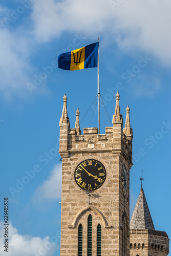 Clock tower of the Parliament Building, Bridgetown in Barbados, West Indies, Caribbean, Lesser Antilles, Central America. Flag of Barbados at the top.