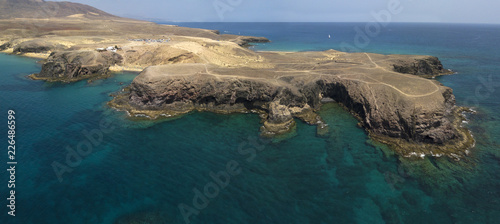 Fototapeta Naklejka Na Ścianę i Meble -  Vista aerea delle coste frastagliate e delle spiagge di Lanzarote, Spagna, Canarie. Strade e sentieri sterrati. Bagnanti in spiaggia. Spiaggia di Papagayo