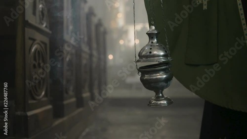 Priest and smoking thurible in a church