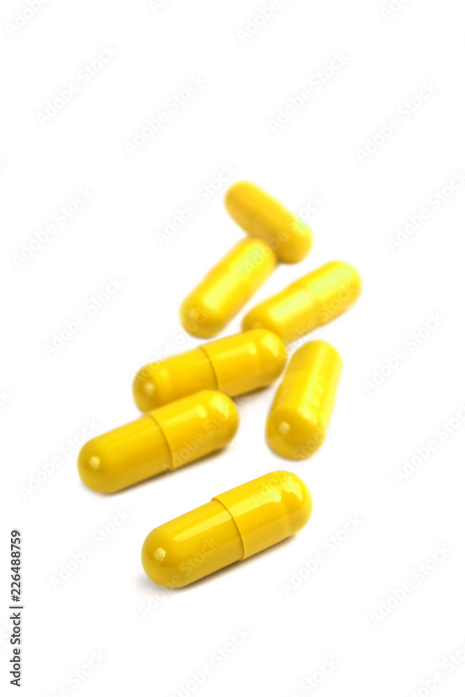 Yellow pill capsules isolated on white background