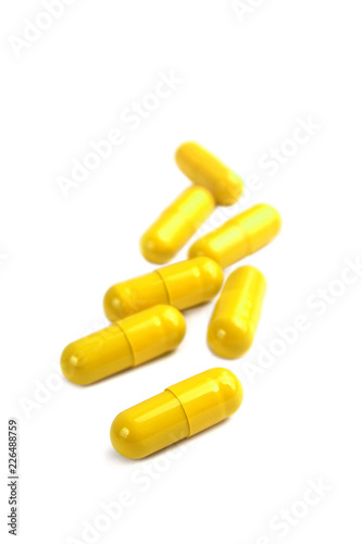Yellow pill capsules isolated on white background