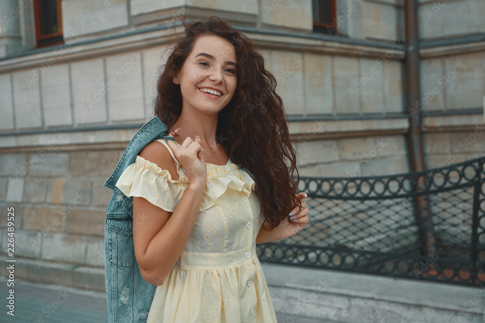 Naklejka premium Portrait of stylish smiling, happy brunette woman walking on the