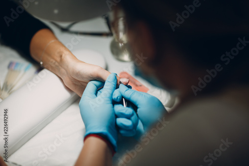 Woman in nail salon applying beauty manicure. Luxury woman hands.