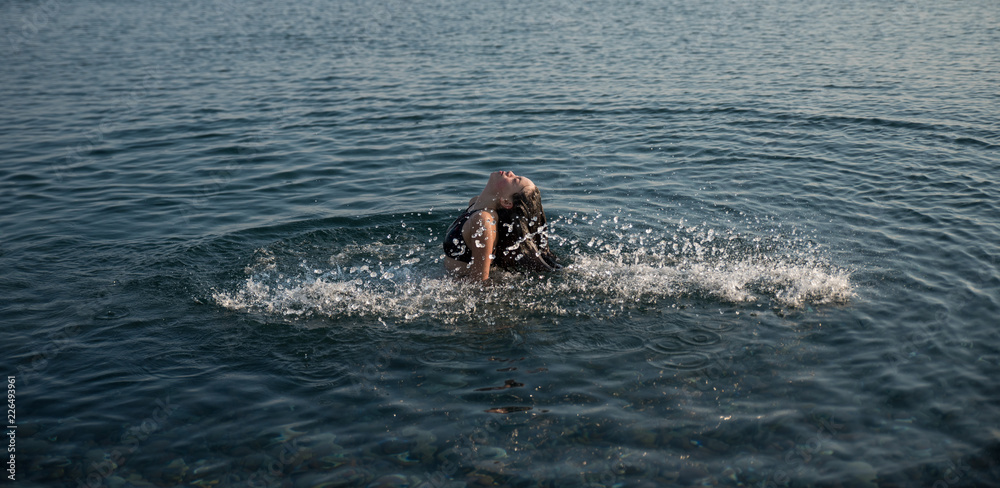 Fototapeta premium teen flipping hair in water and making a splash