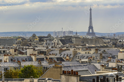 The roofs of Paris and its chimneys under a clouds sky