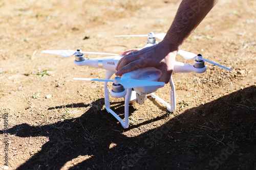 man's hand holding the quadcopter and preparing it for flight