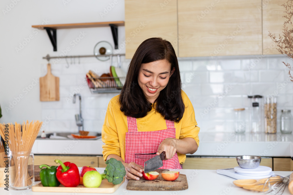 Healthy food Asian woman is cooking salad in kitchen, female preparing the vegetables and fruit at her house