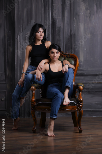 Studio portrait of two sisters on chair