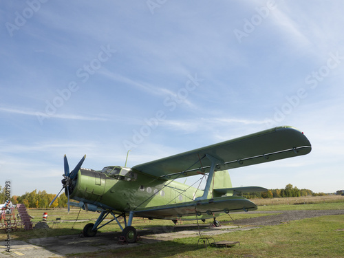 View of classic airplane on the grassy airfield  aircraft after the flight with cases on propellers and other elements  green military aircraft on the runway  historical heritage of Russia