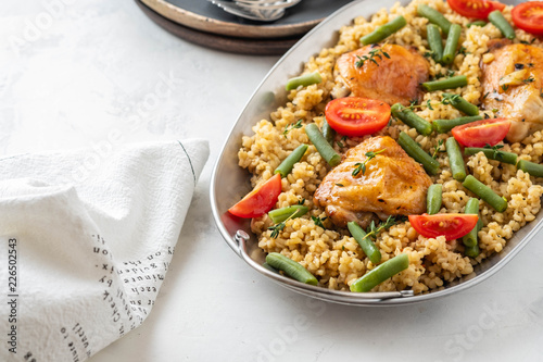 Grilled chicken thighs with bulgur, asparagus beans and tomatoes. Delicious lunch.
