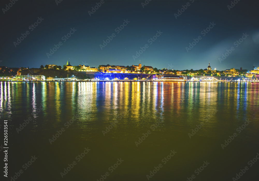 Fototapeta premium Stockholm skyline at night from the harbor Stockholm canal at down with dramatic sky 