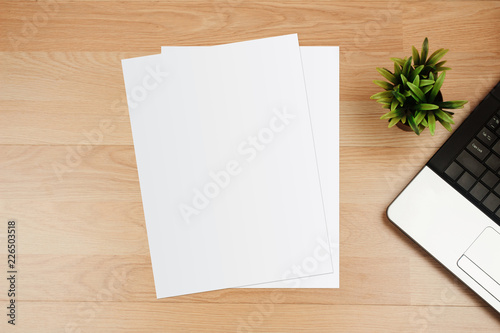White template paper and space for text with laptop on wooden desk