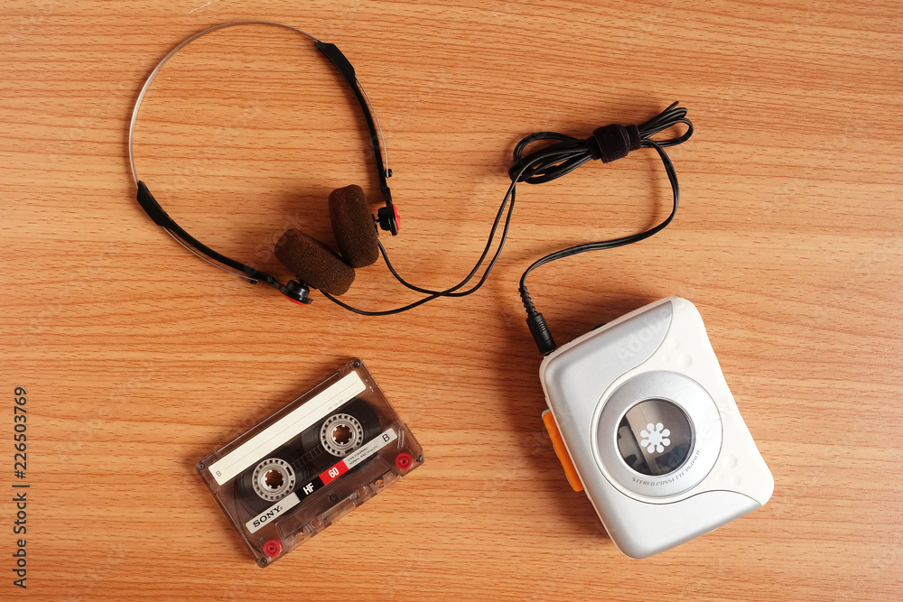 Old portable cassette tape player and headphones on wooden floor Old portable cassette tape player and headphones on wooden floor