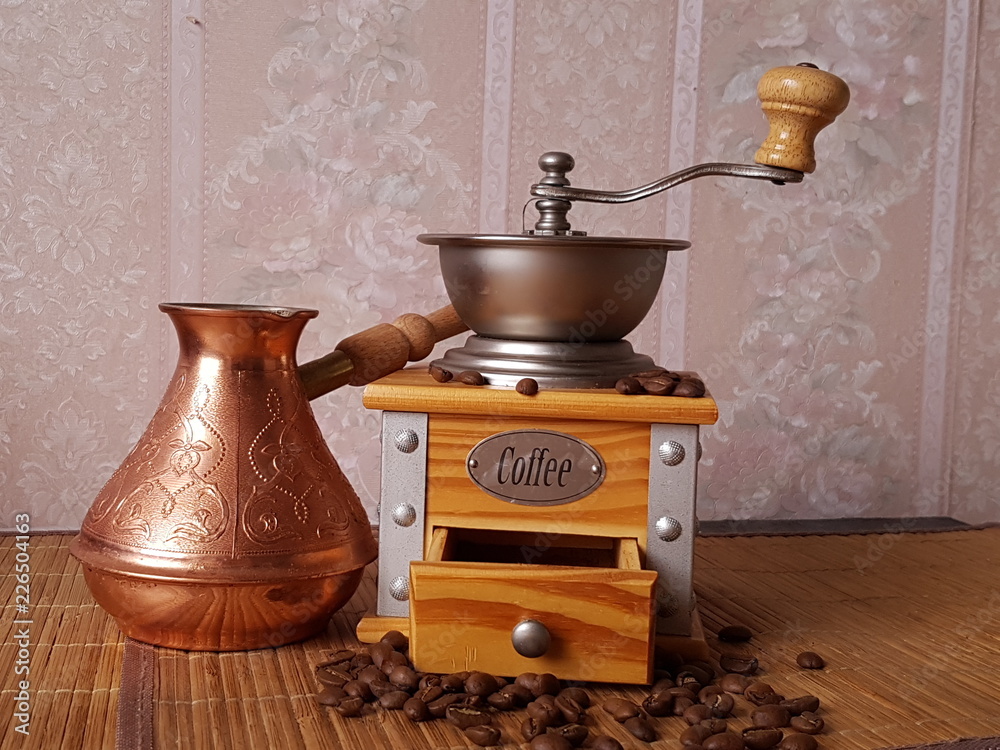 Wooden coffee grinder and cezve on the table