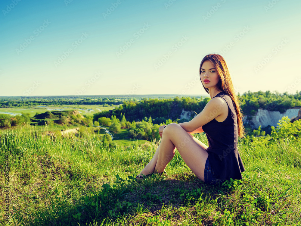 Attractive girl with long hair relaxes outdoor.