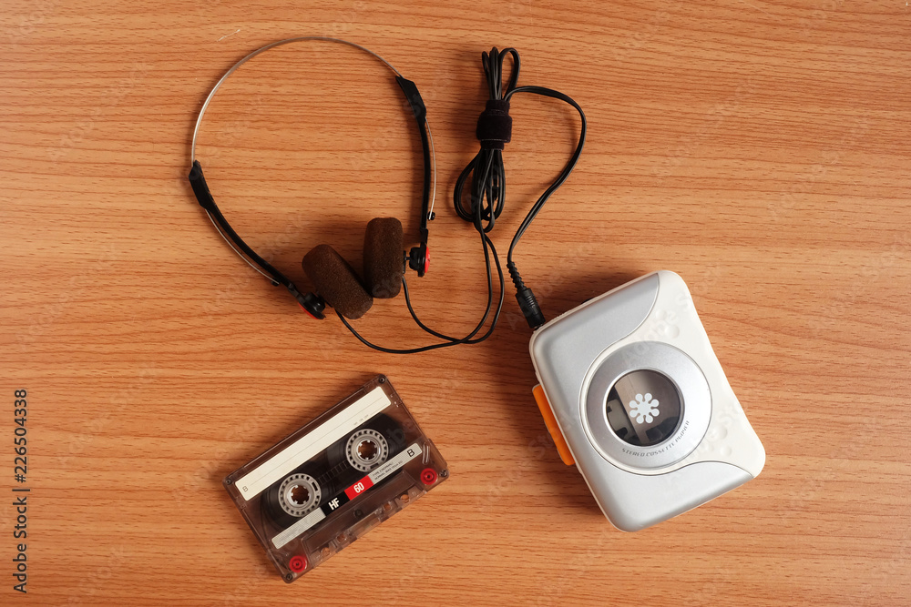 Old portable cassette tape player and headphones on wooden floor Old portable cassette tape player and headphones on wooden floor