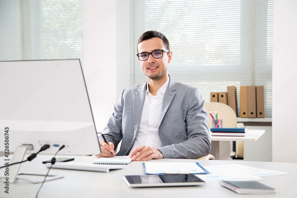 Young handsome businessman working in an office Young handsome businessman working in an office