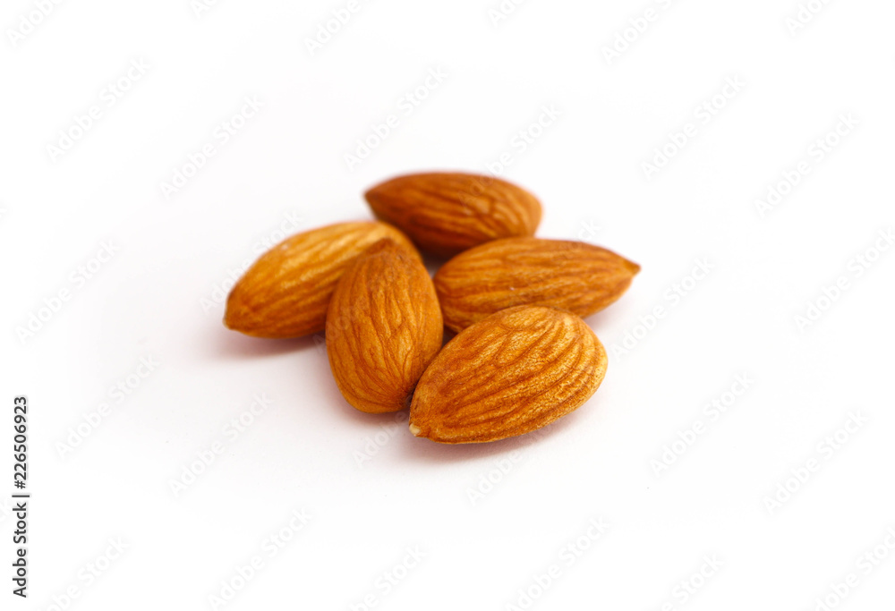 A pile of almond nuts macro view, isolated on white background. A pile of almond nuts macro view, isolated on white background.