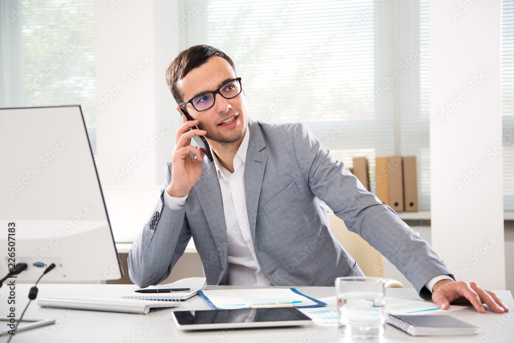 Young handsome businessmantalking on the phone Young handsome businessmantalking on the phone
