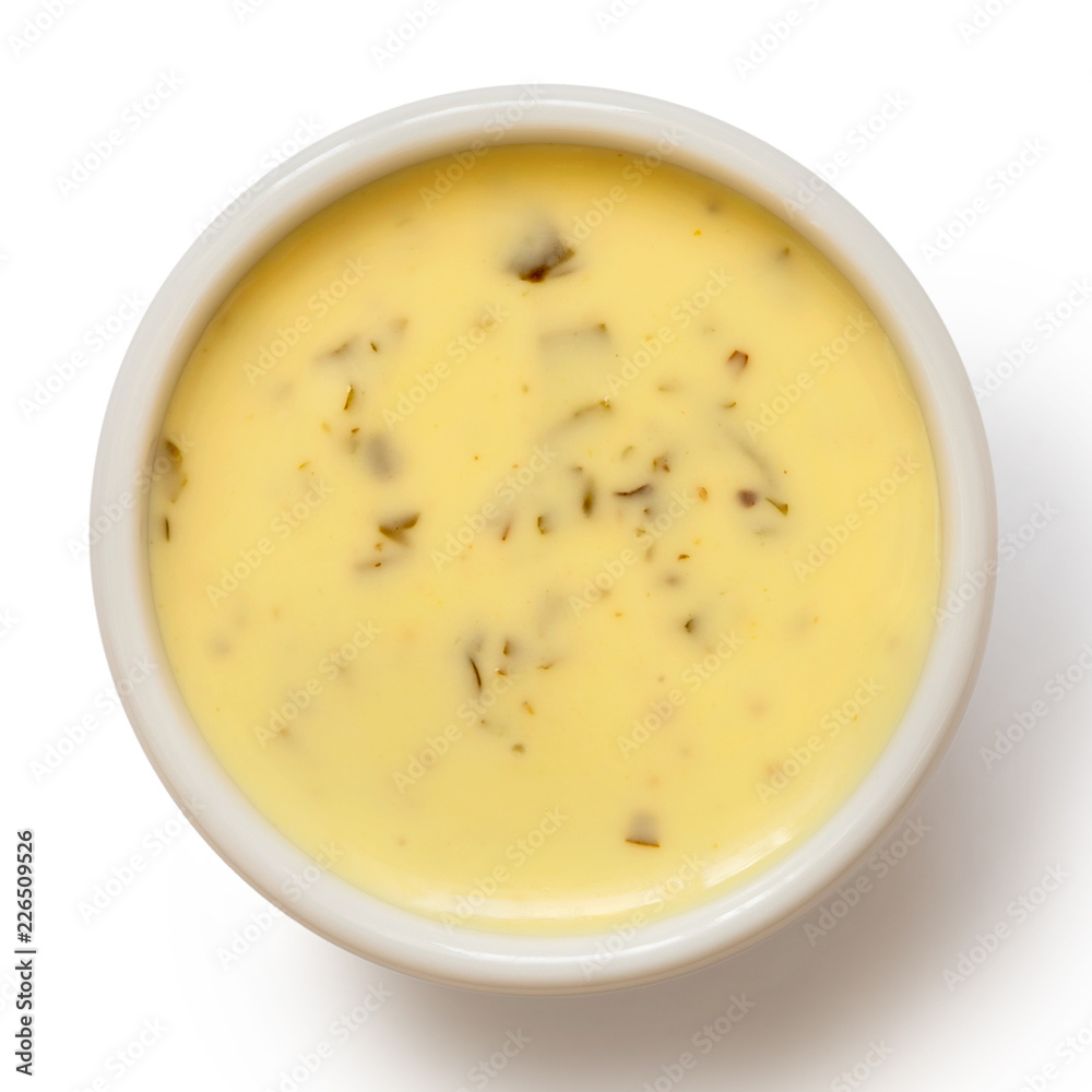 Creamy herb dressing in white ceramic condiment bowl isolated on white from above. Creamy herb dressing in white ceramic condiment bowl isolated on white from above.