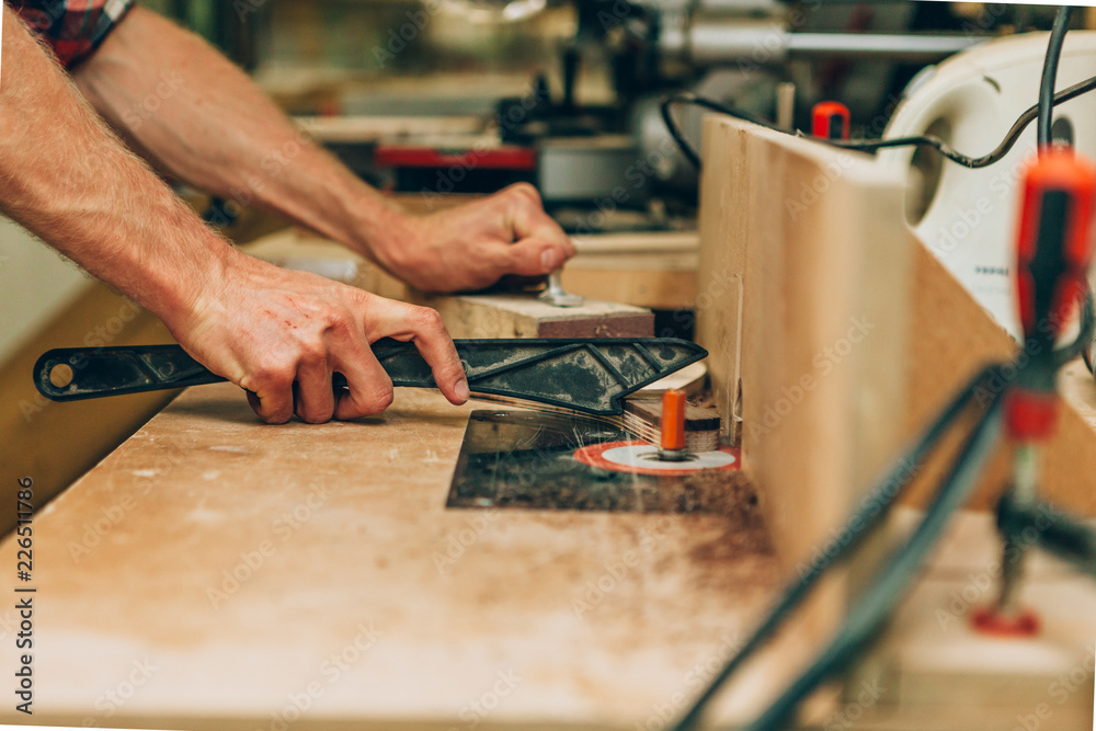 close up of the hands of a carpenter using a lathe close up of the hands of a carpenter using a lathe