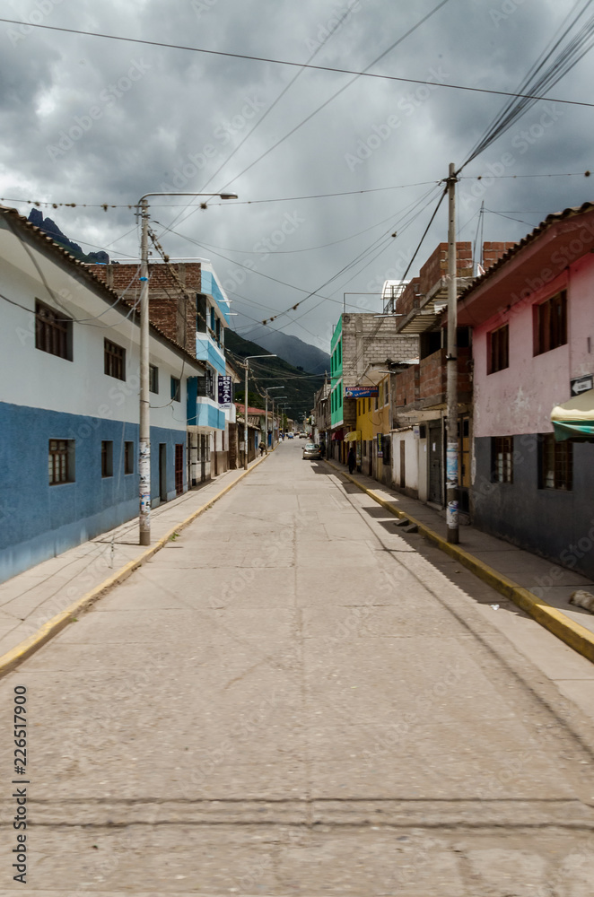 Pisac town street with mountains in the back in a cloudy day, Pisac, Peru