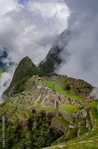 Cloudy morning at Machu Picchu´s starting point with a view of the citadel and some tourists walking, in Peru