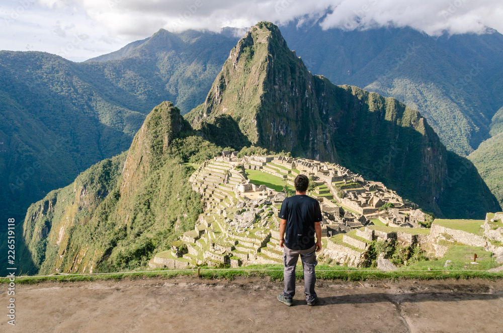 Back of a man admiring the immensity of Machu Picchu