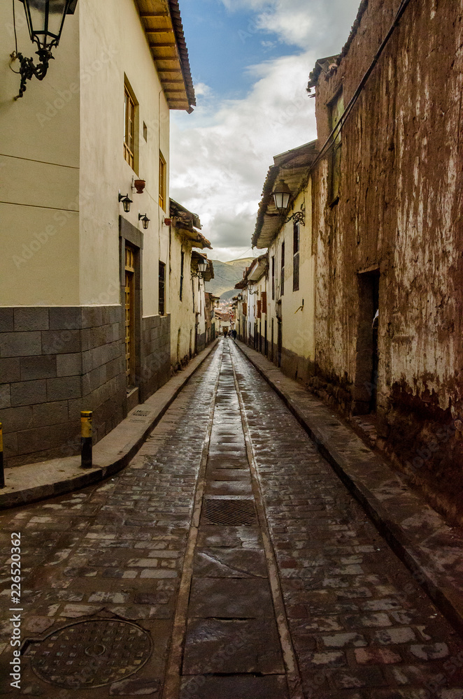 View of a classic cobblestone street with antique buildings in Cusco, Peru