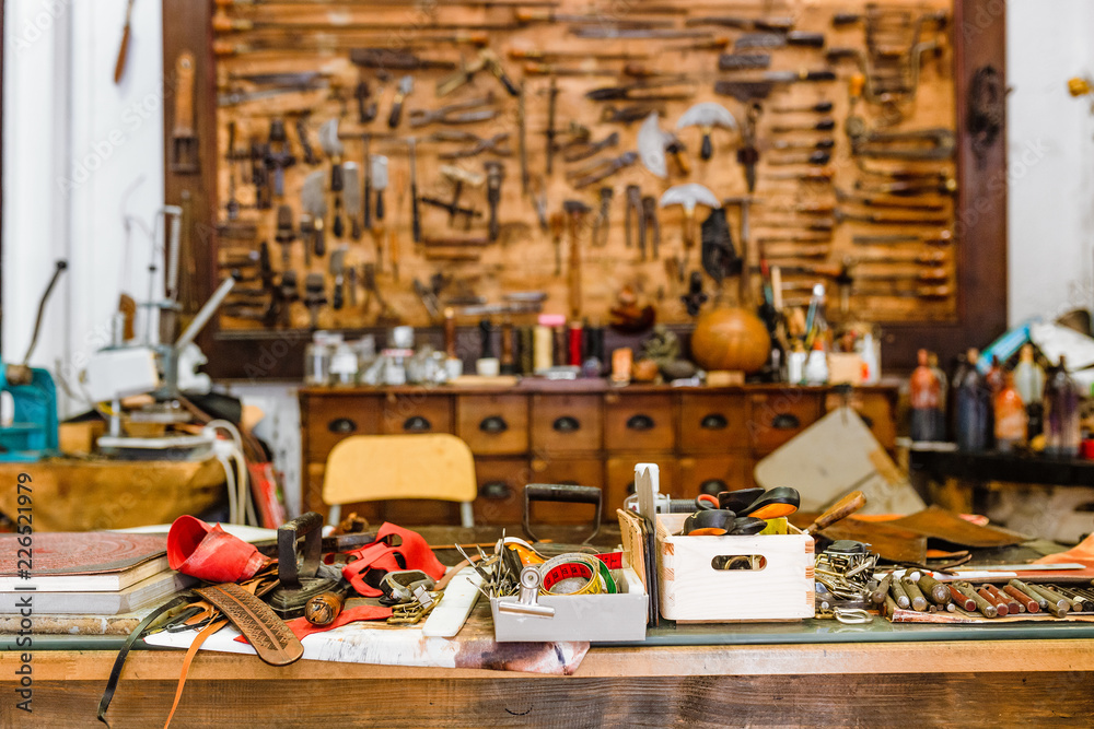 Various old vintage tools on the board in leather craft workshop, manual work concept