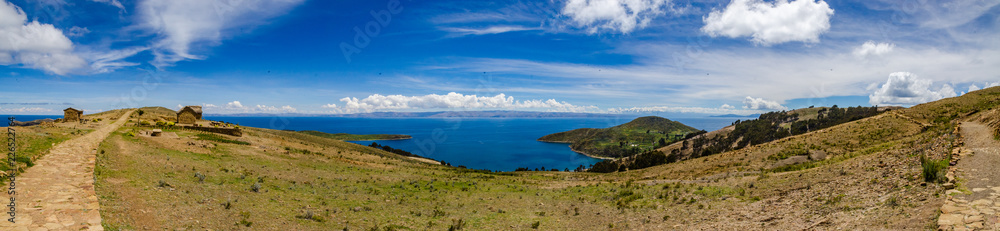 Panoramic on Isla del Sol with a road made of stones, the Titikaka Lake and small constructions on a sunny day Panoramic on Isla del Sol with a road made of stones, the Titikaka Lake and small constructions on a sunny day
