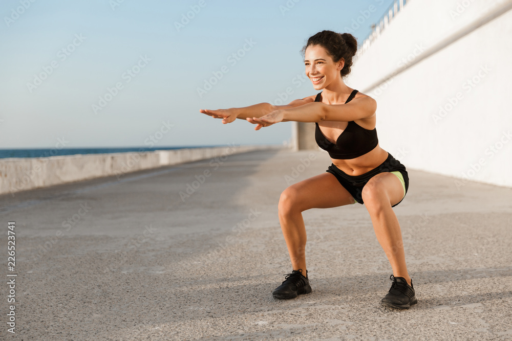 Smiling young sportswoman outdoors at the seaside Smiling young sportswoman outdoors at the seaside