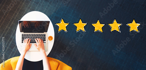 Five Star Rating with person using a laptop on a white table