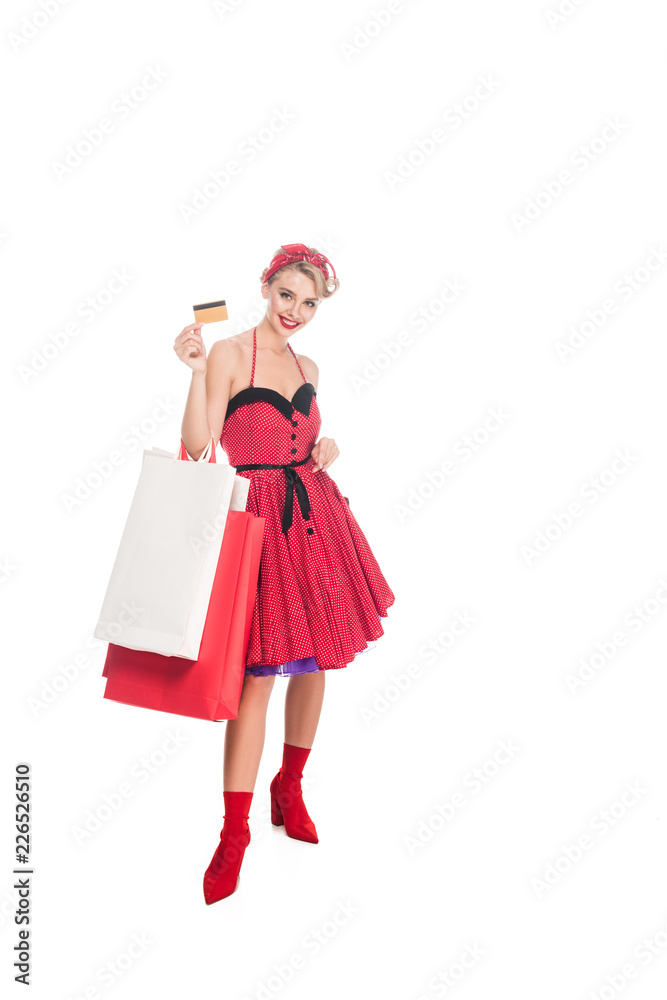 smiling woman in retro pin up clothing with shopping bags showing credit card isolated on white smiling woman in retro pin up clothing with shopping bags showing credit card isolated on white