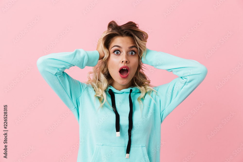 Photo of excited woman in basic clothing screaming and grabbing head, isolated over pink background Photo of excited woman in basic clothing screaming and grabbing head, isolated over pink background