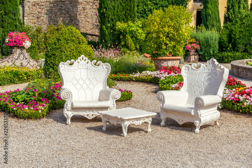 Two big plastic armchairs with white color placed in Tuscany garden photo